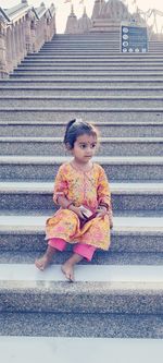 Portrait of young woman sitting on steps