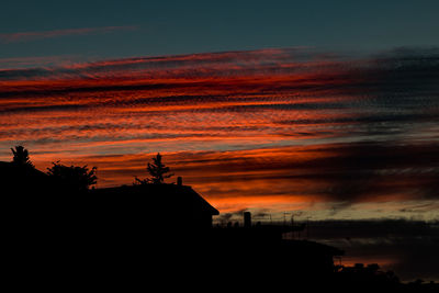 Silhouette of building against dramatic sky