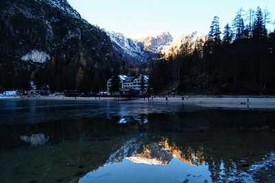 Scenic view of lake by snowcapped mountains against sky