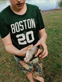 Low section of man holding baby on field