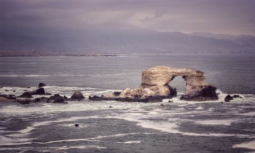 Rocks on beach against sky