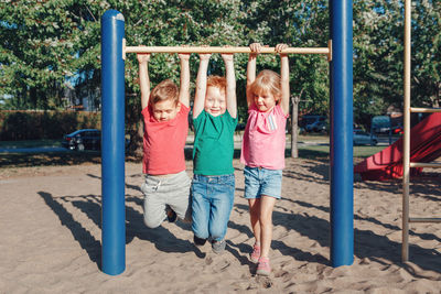 Children hanging on monkey bars at playground