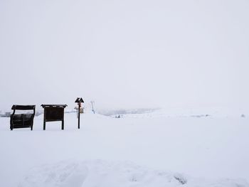 Scenic view of snow covered field against sky