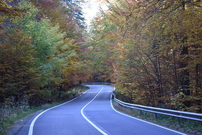 Empty road amidst trees during autumn