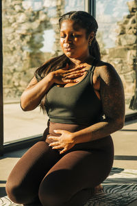 Woman practicing breathing exercise in class at retreat center