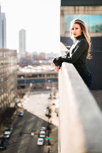 Portrait of woman against sky in city