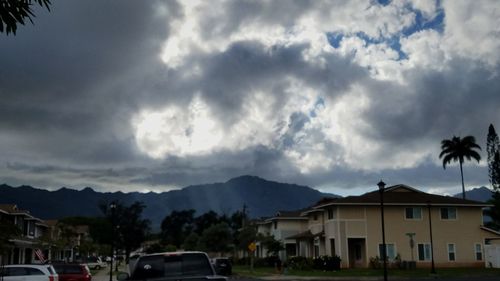 Houses in town against cloudy sky