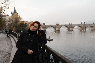 Woman standing on bridge over river during winter