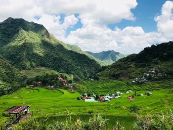 Scenic view of field and mountains against sky