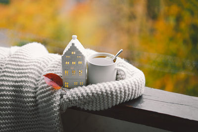 Still life details in home on a wooden window. sweater, hot tea and autumn decor