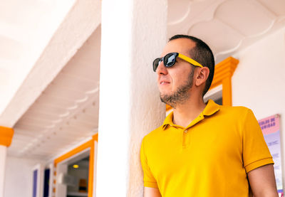 Man wearing sunglasses against wall