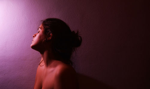 Self portrait of young woman against purple background