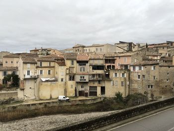 Buildings by road against sky in city