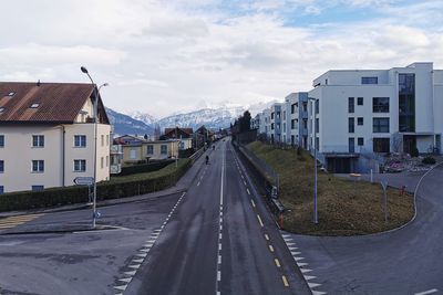 Road amidst buildings against sky