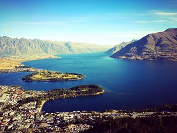 Aerial view of lake and mountains against blue sky