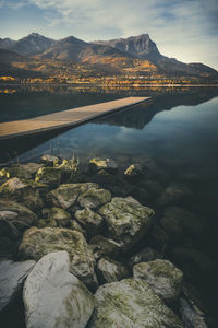 Scenic view of lake by mountains against sky