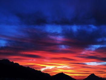 Scenic view of mountains against cloudy sky at sunset