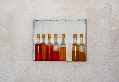 Close-up of bottles on shelf against wall