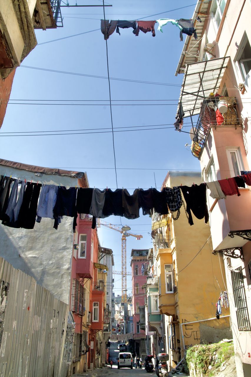 LOW ANGLE VIEW OF CLOTHES DRYING ON BUILDINGS IN CITY