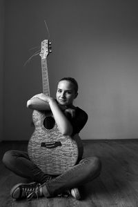 Young woman sitting on guitar