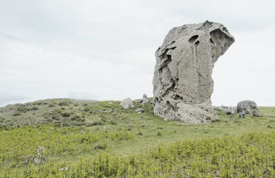 Rocks on field against sky