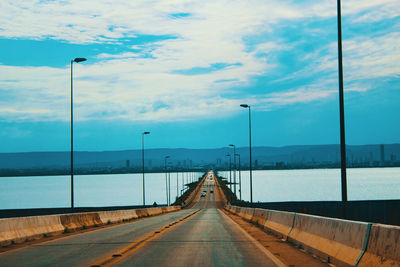 Street amidst sea against sky