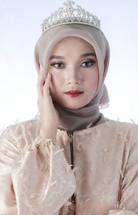 Close-up portrait of young woman over white background