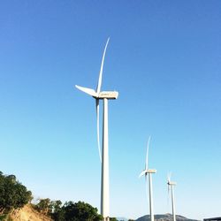 Low angle view of wind turbine against blue sky