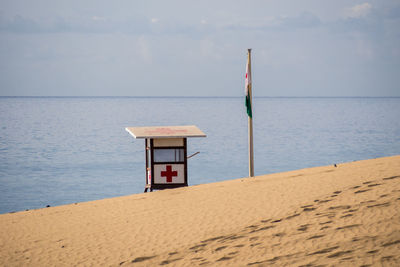 Lifeguard hut on beach against sky