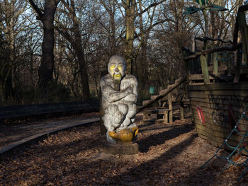 Wooden male sculpture against trees at volkspark hasenheide