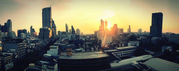 Panoramic view of buildings in city against sky during sunset