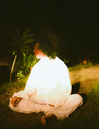 Rear view of woman sitting on field