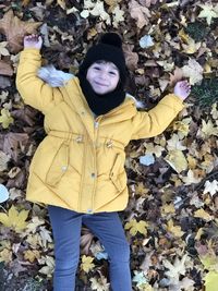 High angle view of girl lying down on autumn leaves