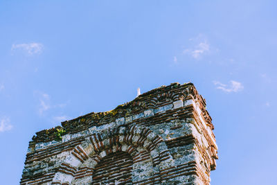 Low angle view of damaged building against blue sky