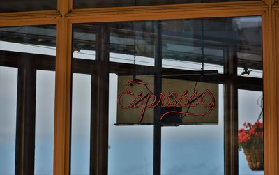 Espresso banner seen through glass door at cafe