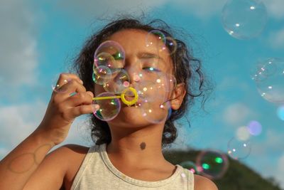 Close-up portrait of woman holding bubbles