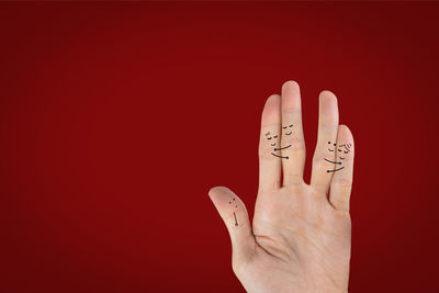 Close-up of human hand against red background