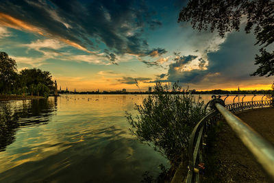 Scenic view of river against sky at sunset