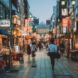 People walking on street amidst buildings in city