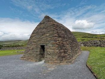 Gallarus oratory against cloudy sky