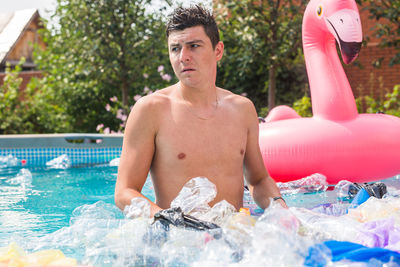 Portrait of shirtless man in swimming pool