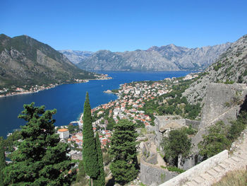 Panoramic shot of townscape by sea against clear blue sky