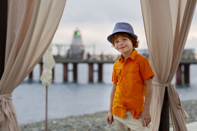 Portrait of boy standing against built structure