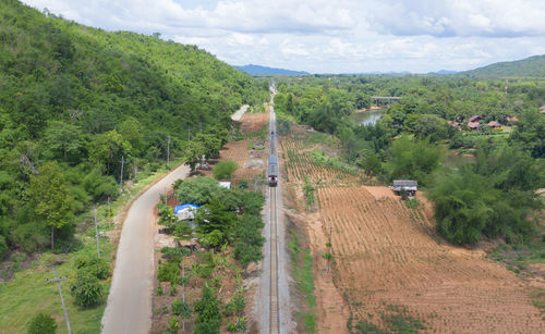 High angle view of road amidst trees against sky