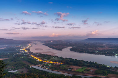 High angle view of townscape by sea against sky during sunset