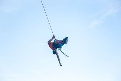 Low angle view of man paragliding against sky