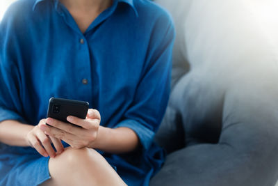 Midsection of man using mobile phone