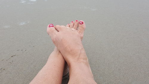 Low section of woman legs on sand