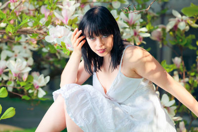 Portrait of young woman against plants