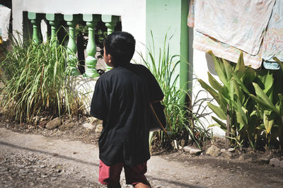 Rear view of man standing in yard